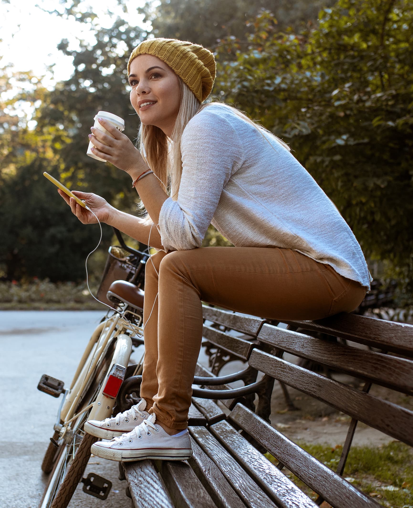 Bewoner ontspant op een parkbank met koffie en fiets bij MORE